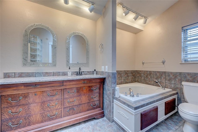 bathroom featuring vaulted ceiling, a bathing tub, tile walls, vanity, and toilet