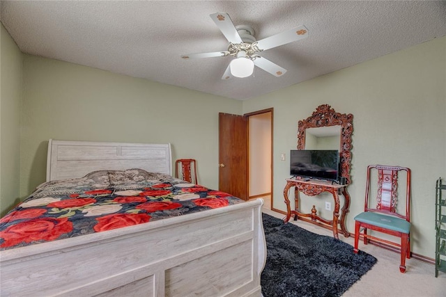 bedroom featuring ceiling fan, carpet, and a textured ceiling