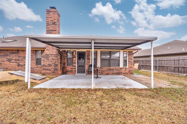 rear view of house with a yard and a patio