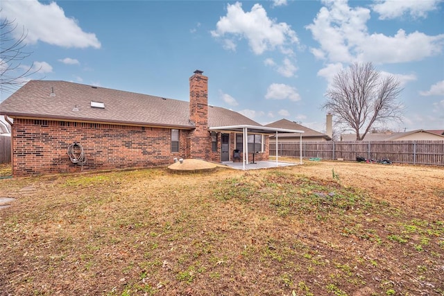 rear view of property with a patio and a lawn