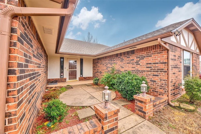 view of exterior entry with a patio