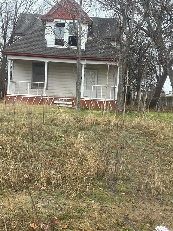 view of front of house with a shingled roof and a porch