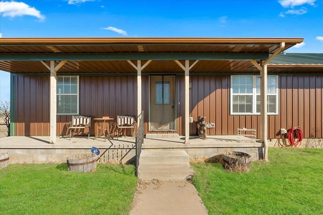 rear view of property with a porch, board and batten siding, and a lawn