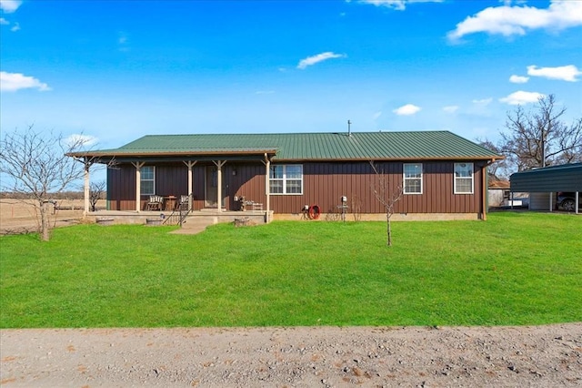 rear view of property with metal roof, a yard, and board and batten siding