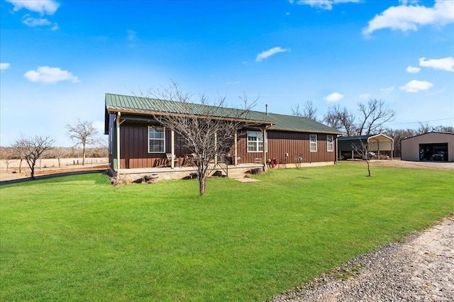 view of front facade featuring dirt driveway, crawl space, metal roof, a carport, and a front lawn