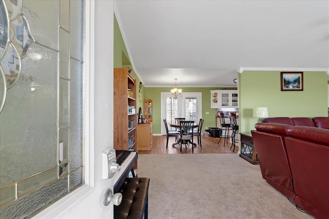 carpeted living room featuring a notable chandelier and crown molding