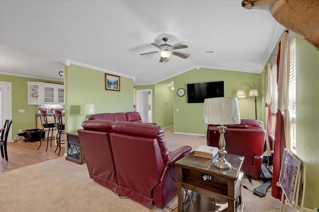 living room featuring vaulted ceiling, carpet floors, ornamental molding, and ceiling fan