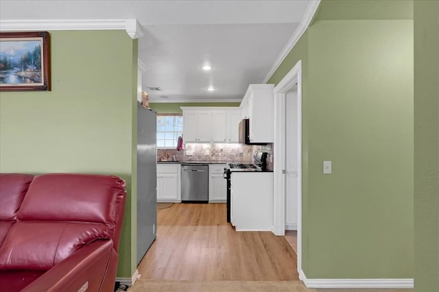 kitchen featuring tasteful backsplash, dark countertops, stainless steel appliances, crown molding, and white cabinetry