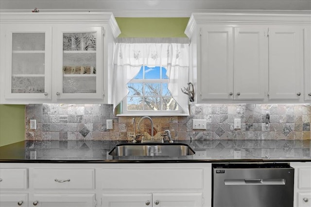 kitchen featuring stainless steel dishwasher, backsplash, a sink, and white cabinets