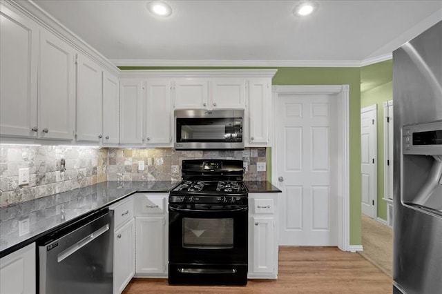 kitchen featuring tasteful backsplash, white cabinets, dark countertops, ornamental molding, and stainless steel appliances