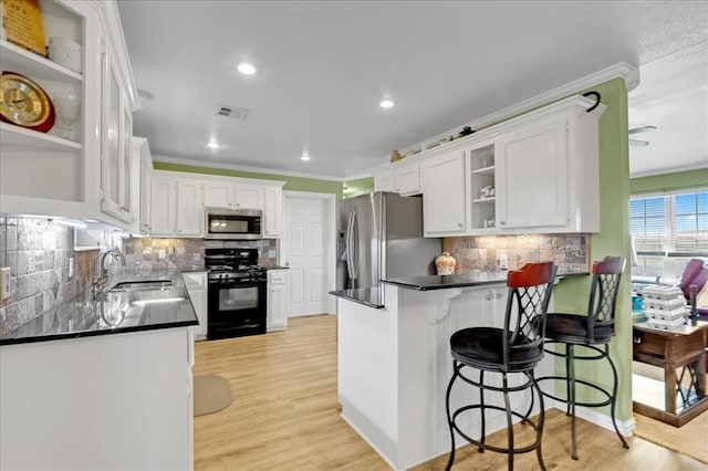 kitchen featuring dark countertops, appliances with stainless steel finishes, a peninsula, crown molding, and open shelves