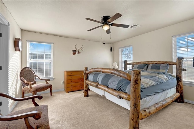 bedroom featuring light carpet, ceiling fan, visible vents, and baseboards