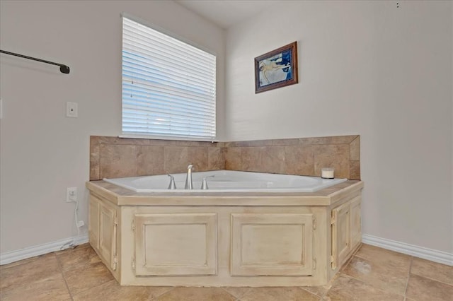 full bathroom with a bath and baseboards