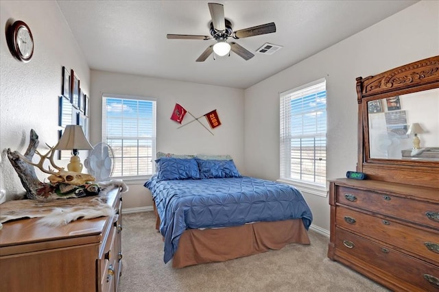 bedroom with light carpet, baseboards, multiple windows, and visible vents