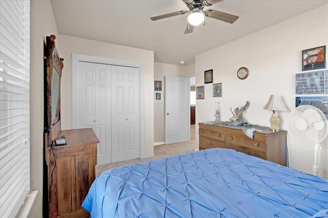 bedroom with a closet, a ceiling fan, and light colored carpet