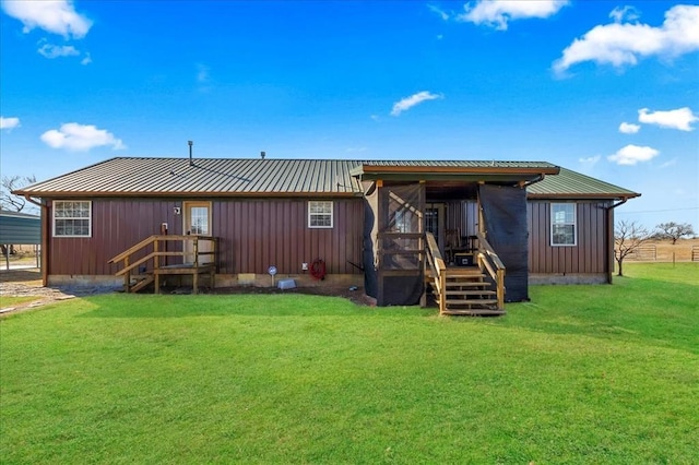 rear view of house featuring board and batten siding, metal roof, and a lawn