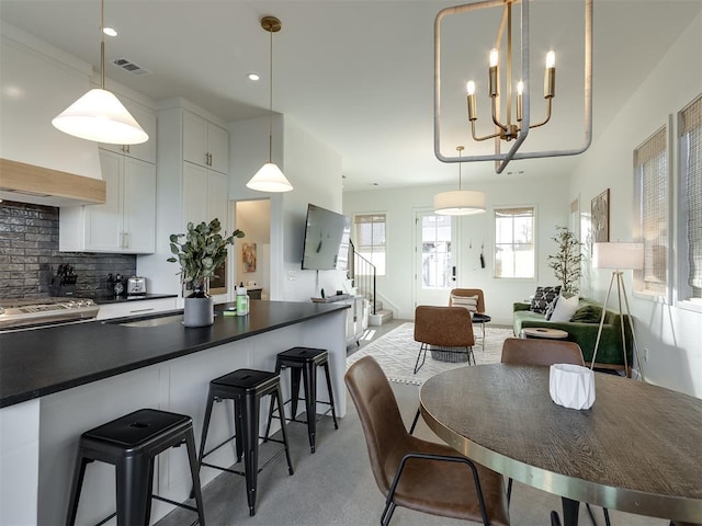 carpeted dining space with sink and a notable chandelier