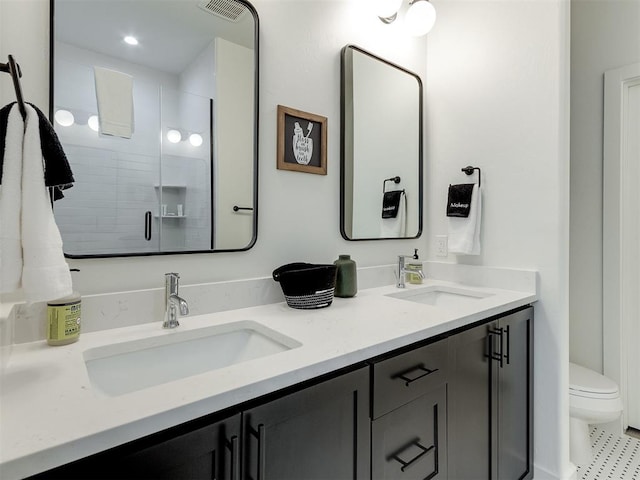 bathroom featuring vanity, toilet, and an enclosed shower