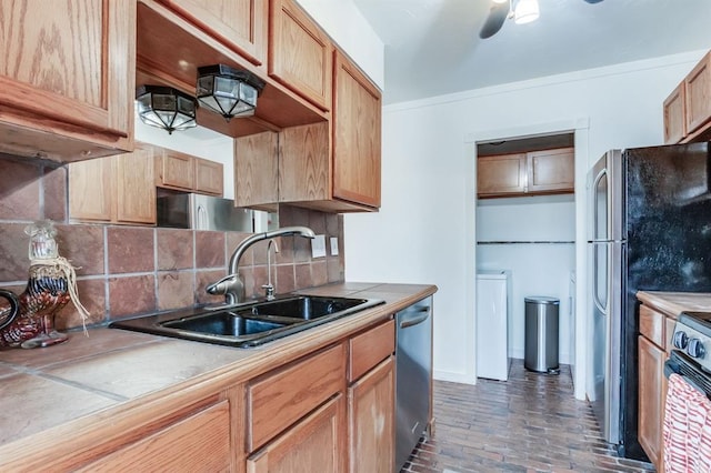 kitchen with stainless steel appliances, sink, backsplash, and ceiling fan