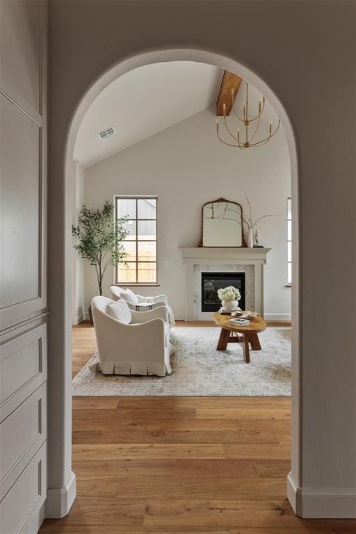 living room with hardwood / wood-style floors, a fireplace, and lofted ceiling with beams