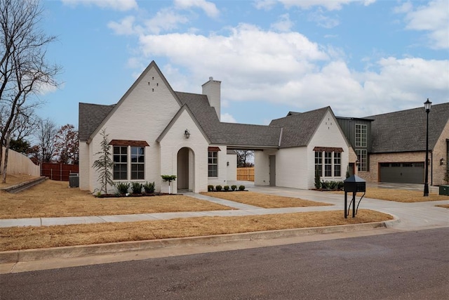 french country style house featuring a garage and cooling unit