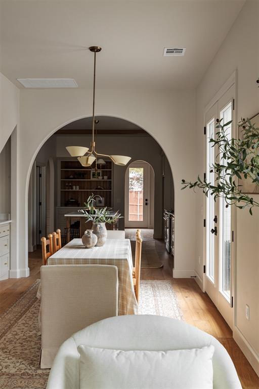 dining room featuring lofted ceiling, wood-type flooring, and built in features