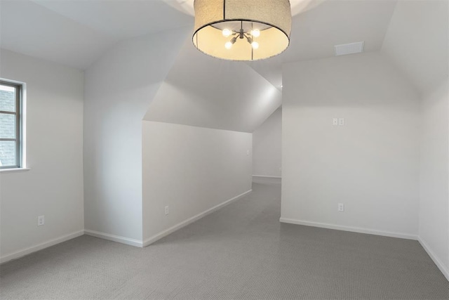 additional living space featuring lofted ceiling and carpet flooring