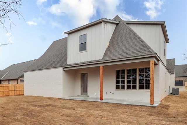 back of house with central AC, a patio area, and a lawn