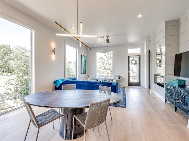 dining room with recessed lighting, plenty of natural light, and light wood-style floors