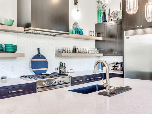 kitchen with high quality appliances, light stone counters, hanging light fixtures, open shelves, and a sink