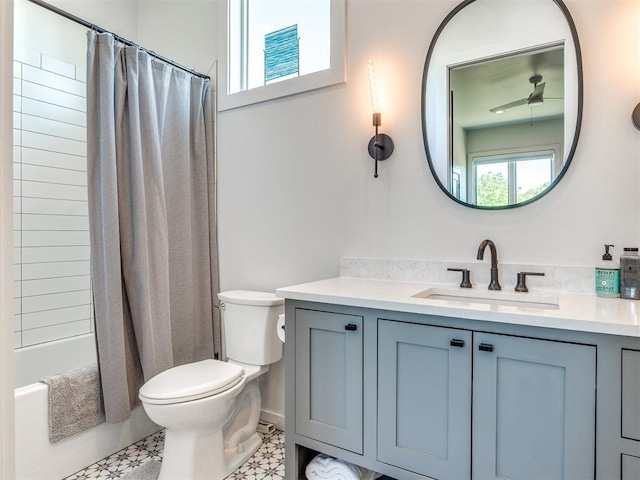 bathroom with toilet, a ceiling fan, vanity, and shower / tub combo with curtain