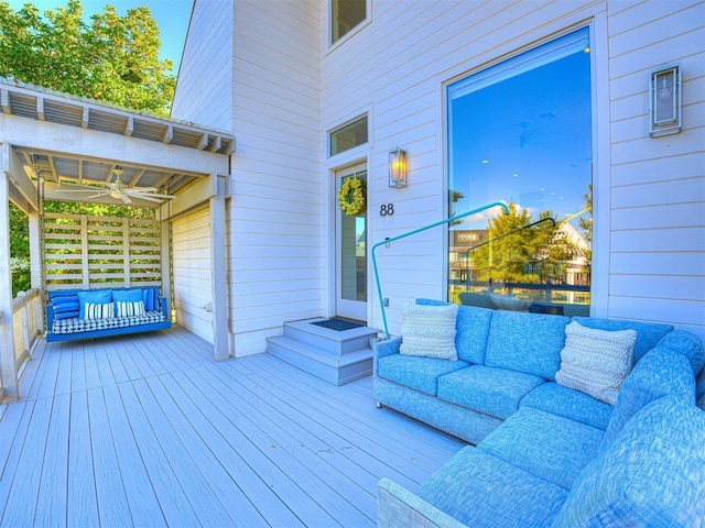 wooden terrace featuring ceiling fan and an outdoor living space