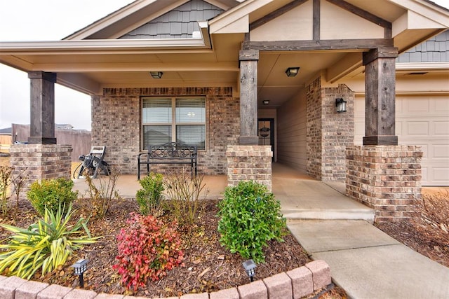 view of exterior entry featuring a garage and covered porch