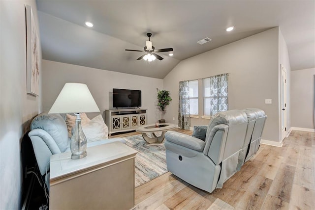 living room featuring ceiling fan, lofted ceiling, and light wood-type flooring