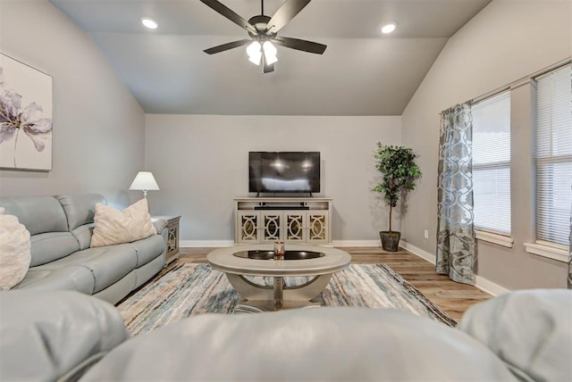 living room with ceiling fan, lofted ceiling, and light hardwood / wood-style floors