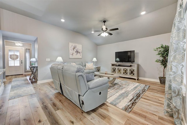 living room with vaulted ceiling, ceiling fan, and light wood-type flooring