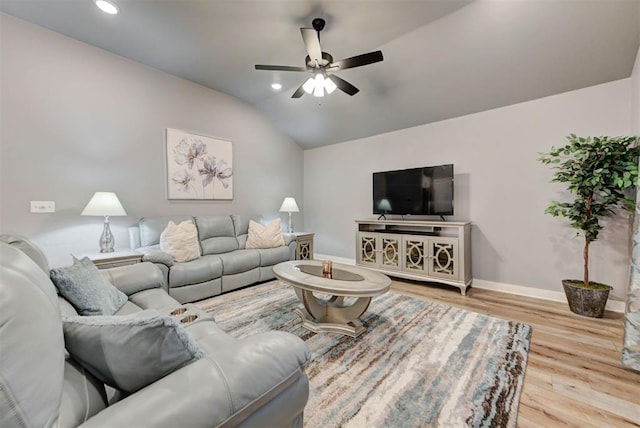 living room featuring ceiling fan, lofted ceiling, and light hardwood / wood-style flooring