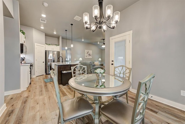 dining space featuring ceiling fan, sink, and light hardwood / wood-style floors