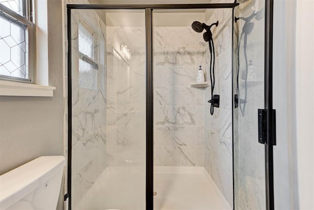 bathroom featuring toilet and an enclosed shower