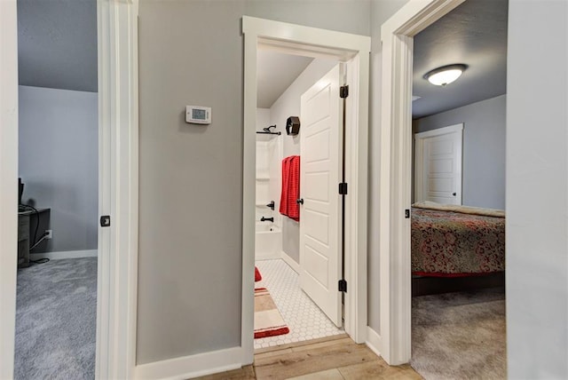 bathroom with wood-type flooring and washtub / shower combination