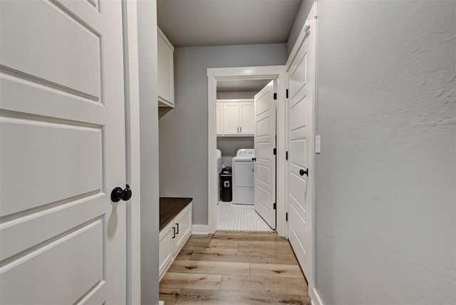 mudroom with washing machine and clothes dryer and light hardwood / wood-style floors