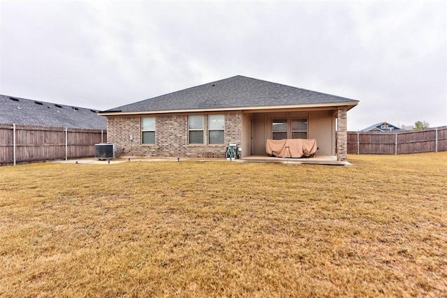 rear view of property with central AC unit, a yard, and a patio area