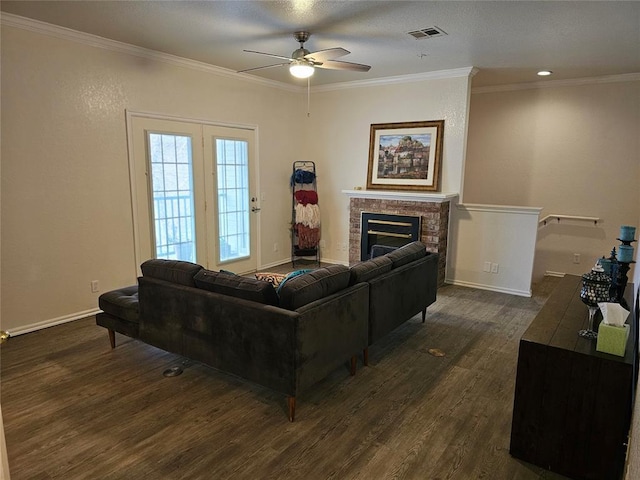 living room featuring a brick fireplace, crown molding, dark hardwood / wood-style floors, and ceiling fan