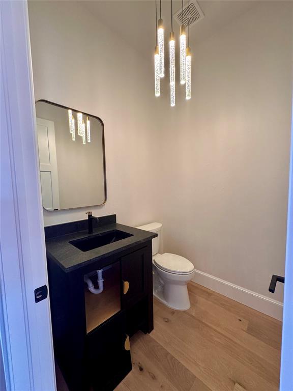 bathroom with vanity, hardwood / wood-style floors, and toilet