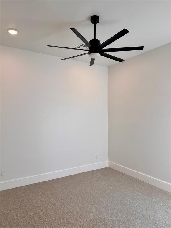 unfurnished room with ceiling fan and carpet flooring