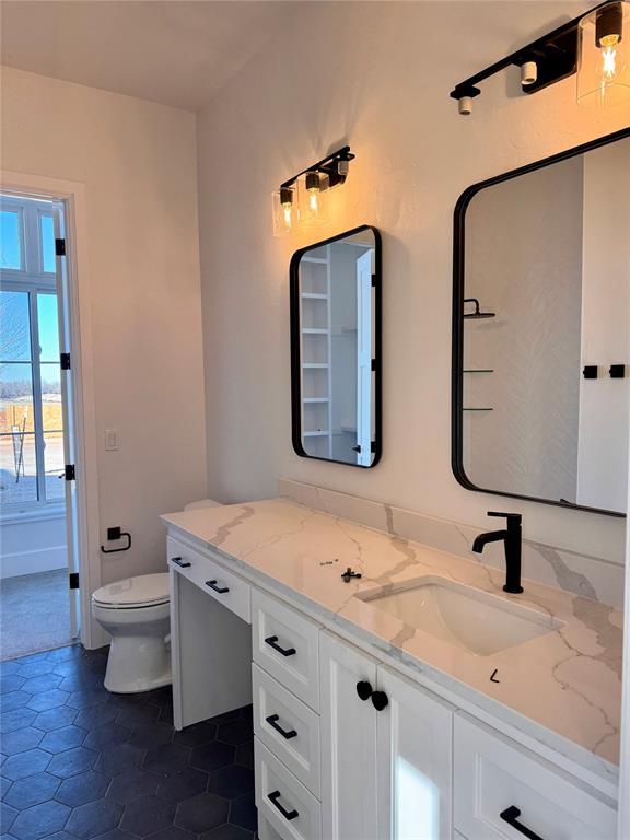 bathroom with vanity, tile patterned flooring, and toilet