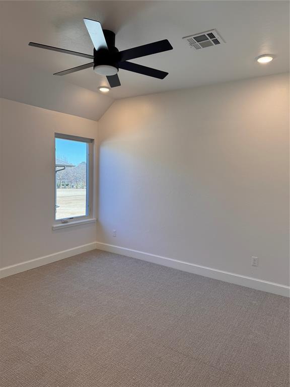 spare room with lofted ceiling, carpet floors, and ceiling fan