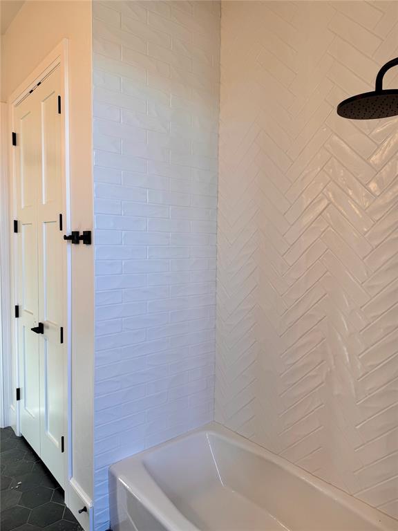 bathroom featuring tile patterned flooring and shower / tub combination