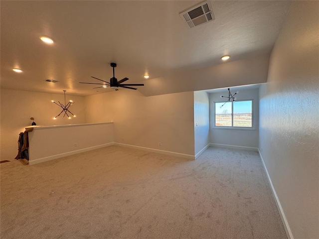 spare room with light carpet, baseboards, visible vents, and ceiling fan with notable chandelier