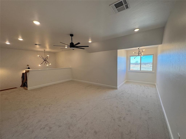 empty room featuring light carpet, ceiling fan with notable chandelier, visible vents, and baseboards